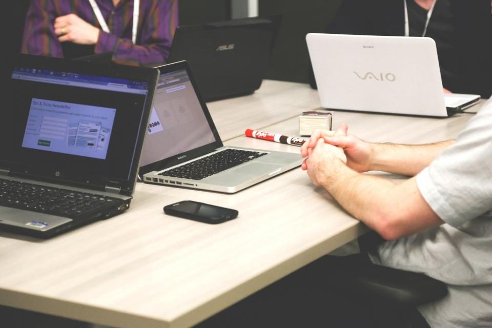 Varias personas trabajando con portatiles alrededor de una mesa