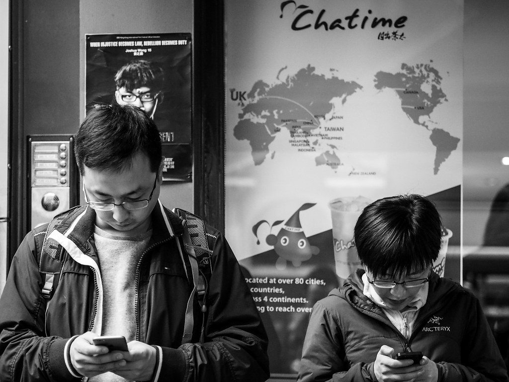 Dos personas en la calle mirando sus telefonos moviles